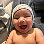 baby, smiling, hat, knit_hat, bare_chest, infant, happy, face, portrait, lying_down, blanket, indoor, skin, cute, child, person, newborn, expression, comfort, cozy