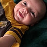 Nashtyn is registered to the contest to win money with this photo: baby, smile, child, infant, blanket, yellow_shirt, brown_stripes, happy, face, portrait, cute, lying_down, indoors, cozy, skin, eyes, arm, expression, young, clothing