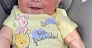 Nashtyn is registered to the contest to win money with this photo: baby, car_seat, onesie, winnie_the_pooh, piglet, yellow_clothing, smile, happy, infant, child, sunlight, seatbelt_warning_label, cute, portrait, skin, hand, legs, face, person, indoor