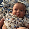 baby, infant, onesie, blanket, bed, smile, face, expression, diaper, human, child, cute, skin, indoor, relax, comfort, person, clothing, happy, portrait