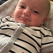 Nashtyn is registered to the contest to win money with this photo: baby, infant, smile, striped_clothing, onesie, indoor, cozy, furniture, face, child, soft_lighting, cute, hand, expression, casual, relaxed, home, portrait, young_child, person