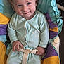 baby, infant, smile, face, child, onesie, seat, baby_seat, colorful, cushion, fabric, hand, cute, happy, indoors, soft, comfort, blue, green, purple