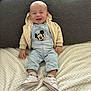 Maëlo a rejoint le concours — aidez-le/la à gagner de superbes lots ! baby, smiling, mickey_mouse, overall, hoodie, sneakers, white_shoes, blanket, couch, indoor, happy, child, infant, clothing, casual, cute, portrait, sitting, cozy, home