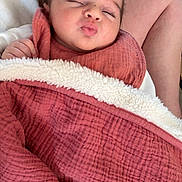 Agathe a rejoint le concours — aidez-le/la à gagner de superbes lots ! baby, blanket, person, face, sleeping, cozy, indoor, hand, clothing, footwear, carpet, couch, pucker, infant, resting, skin, soft, warm, relaxed, lap