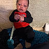baby, infant, child, couch, blanket, pacifier, clothing, red, black, beige, blue, hand, face, sitting, indoors, cute, young, person, portrait, cozy