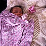 baby, blanket, sleeping, plush_toy, teddy_bear, pacifier, infant, cozy, soft, cute, child, face, floral_pattern, resting, comfort, indoors, wrapped, peaceful, pink, fabric