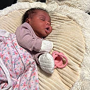 Tatem is registered to the contest to win money with this photo: baby, sleeping, blanket, floral, mittens, pacifier, plush, cushion, bear_shape, infant, pink, cream, soft, rest, cozy, closeup, cute, child, indoors, peaceful