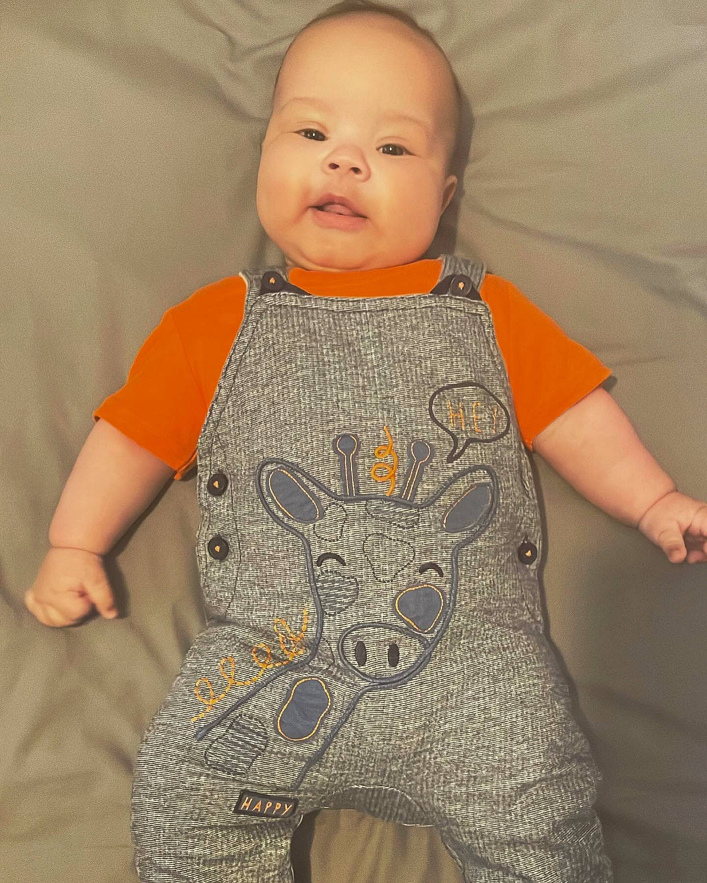 Jayden is registered to the contest to win money with this photo: baby, baby_toddler_clothing, cheek, child, collar, comfort, face, fashion_design, linens, neck, one_piece_garment, pattern, peach, person, sitting, skin, sleeve, textile, thumb, toddler