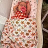 baby, sleeping, pacifier, blanket, floral_pattern, bassinet, infant, arms_up, cushion, sleepwear, indoors, resting, child, cute, peaceful, portrait, soft_lighting, comfort, nap, cozy