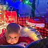 baby, child, reading, book, bedtime, christmas, holiday, lights, festive, decorations, joy, red, cozy, indoors, portrait, cute, glow, pillow, plaid, santa_hat