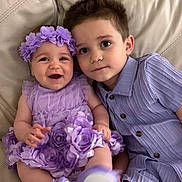 Valentina is registered to the contest to win money with this photo: baby, child, toddler, sibling, lavender, flower_headband, smiling, couch, leather, portrait, happy, cute, indoor, clothing, young_child, family, sitting, together, cute_outfit, head