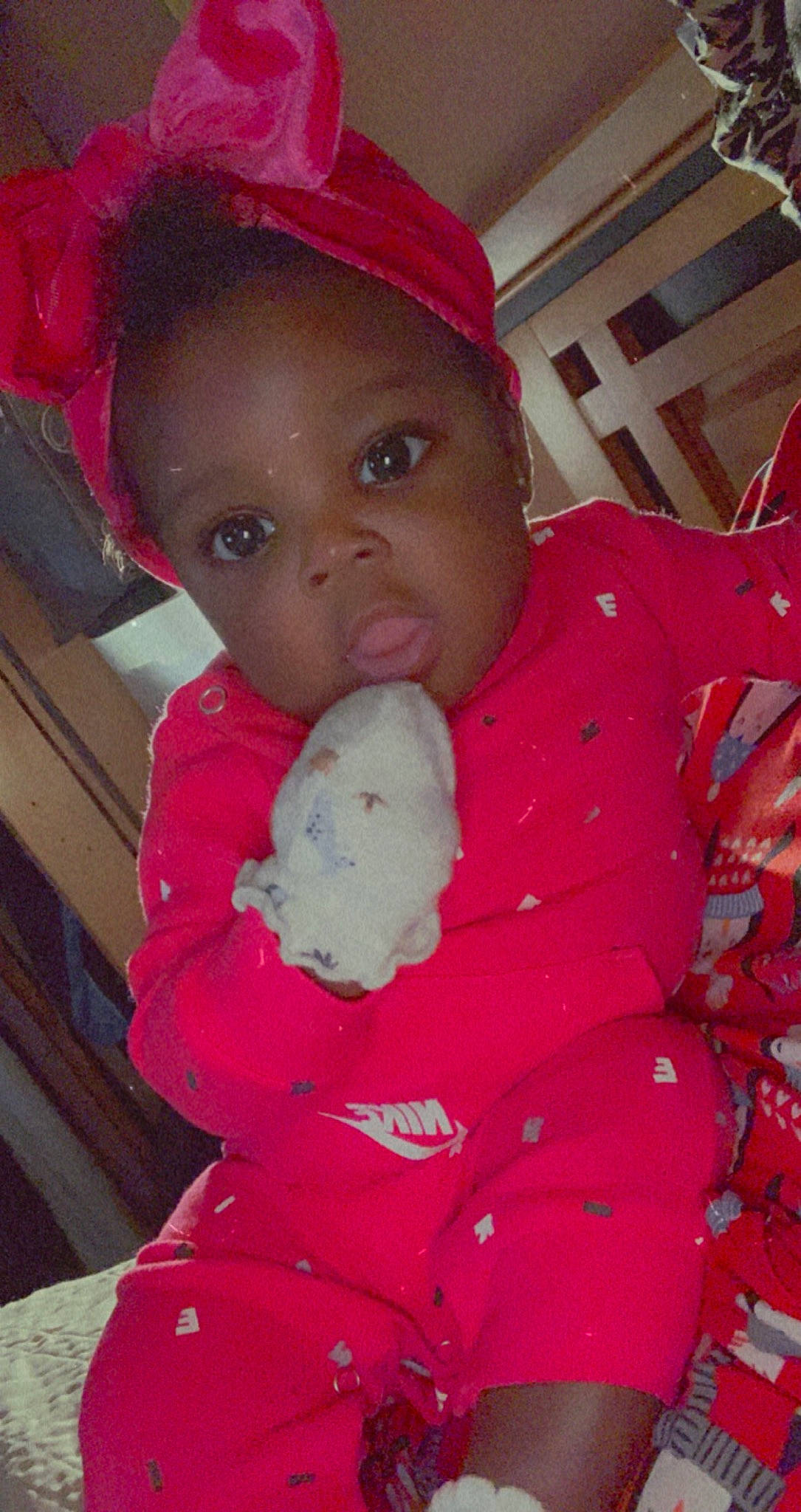 Nevaeh is registered to the contest to win money with this photo: baby, baby_toddler_clothing, cap, cheek, child, face, happy, human_body, lip, mammal, mouth, nose, outerwear, person, pink, red, skin, sleeve, stuffed_toy, textile