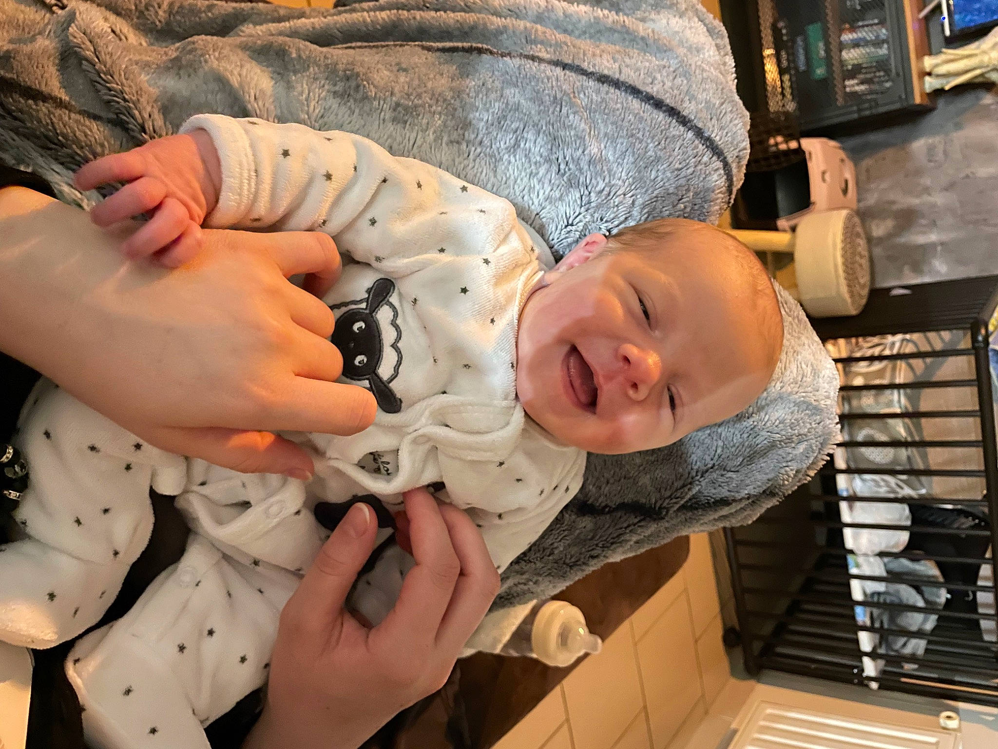 Délia a rejoint le concours — aidez-le/la à gagner de superbes lots ! baby, baby_products, baby_toddler_clothing, cheek, child, comfort, face, facial_expression, finger, fun, human_body, mammal, mouth, pattern, person, room, sitting, skin, smile, toddler