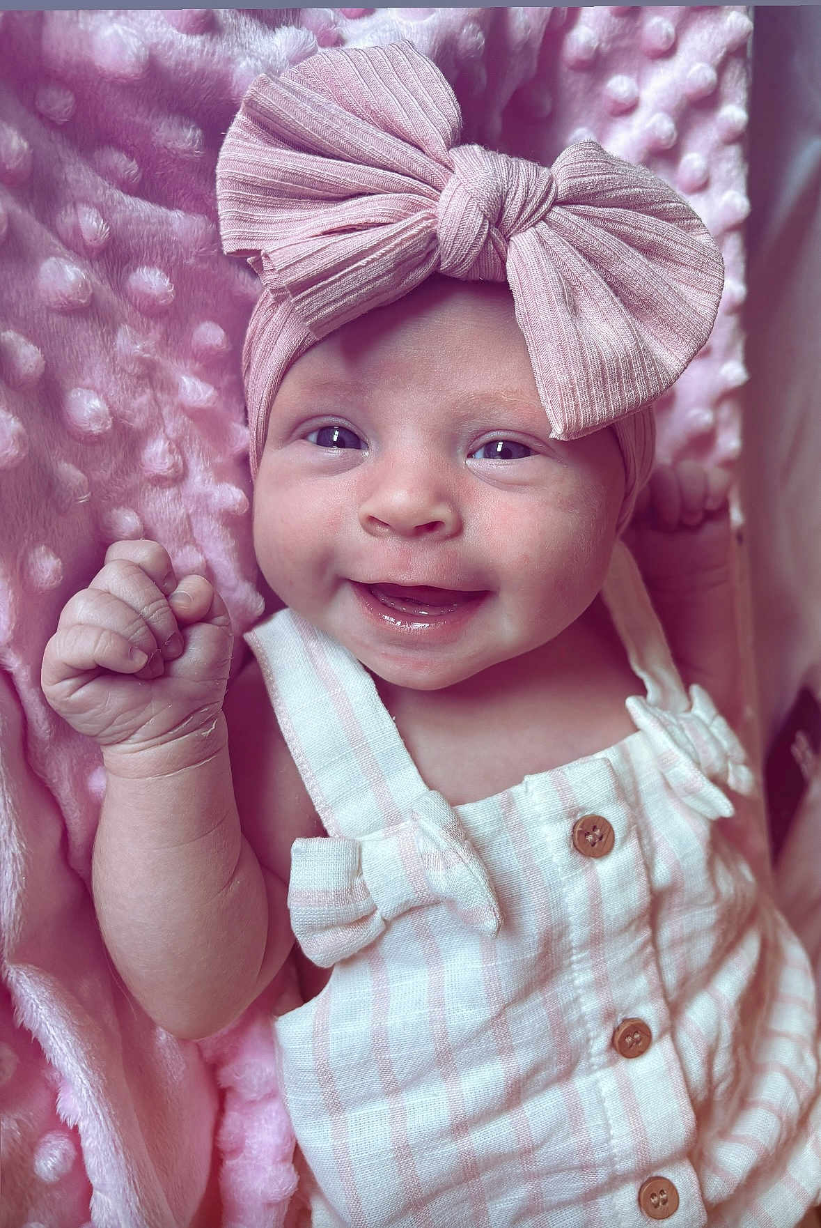 Isla-Rose is registered to the contest to win money with this photo: baby, smiling, infant, pink_bow, headband, blanket, soft_texture, clothing, cute, happy, portrait, closeup, skin, hand, buttoned_outfit, baby_girl, lying_down, baby_fashion, adorable, newborn