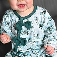 Gracelyn joined the competition — help win amazing prizes! baby, child, smiling, headband, bow, onesie, floral_pattern, blue_eyes, sitting, cute, infant, clothing, happy, portrait, closeup, skin, hand, foot, indoors, soft_light