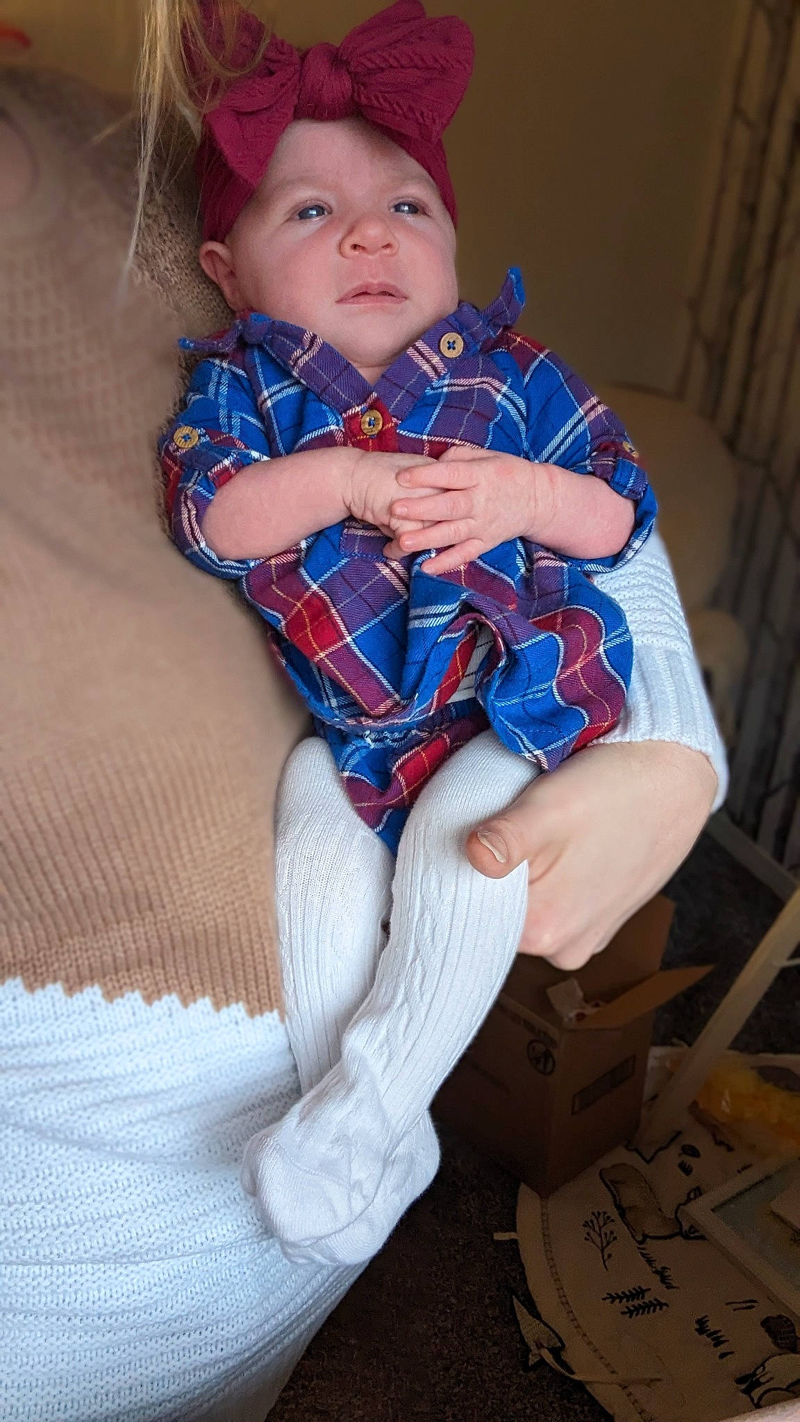Willow is registered to the contest to win money with this photo: arm, baby_toddler_clothing, clothing, electric_blue, eye, face, hand, head, headwear, human_body, human_leg, iris, pattern, person, plaid, skin, sleeve, sock, textile, thigh