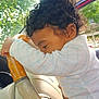 Gabriel is registered to the contest to win money with this photo: toddler, child, car, steering_wheel, curly_hair, sunlight, window, trees, interior, seat, hand, clothing, white_outfit, closeup, portrait, cute, daylight, person, car_key, dashboard