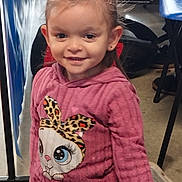 Maya a rejoint le concours — aidez-le/la à gagner de superbes lots ! cartoon_bunny, casual_wear, chair, child, cute, earrings, face, floor, girl, hair_tied, happy, hoodie, indoor, person, pink_clothing, portrait, smile, standing, table, young_child