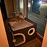 animal, cat, cat_house, cozy, curtain, door_frame, feline, home, indoor, looking_out, night, orange_cat, pet, quiet, relaxed, resting, soft_lighting, tile_floor, white_cat, window