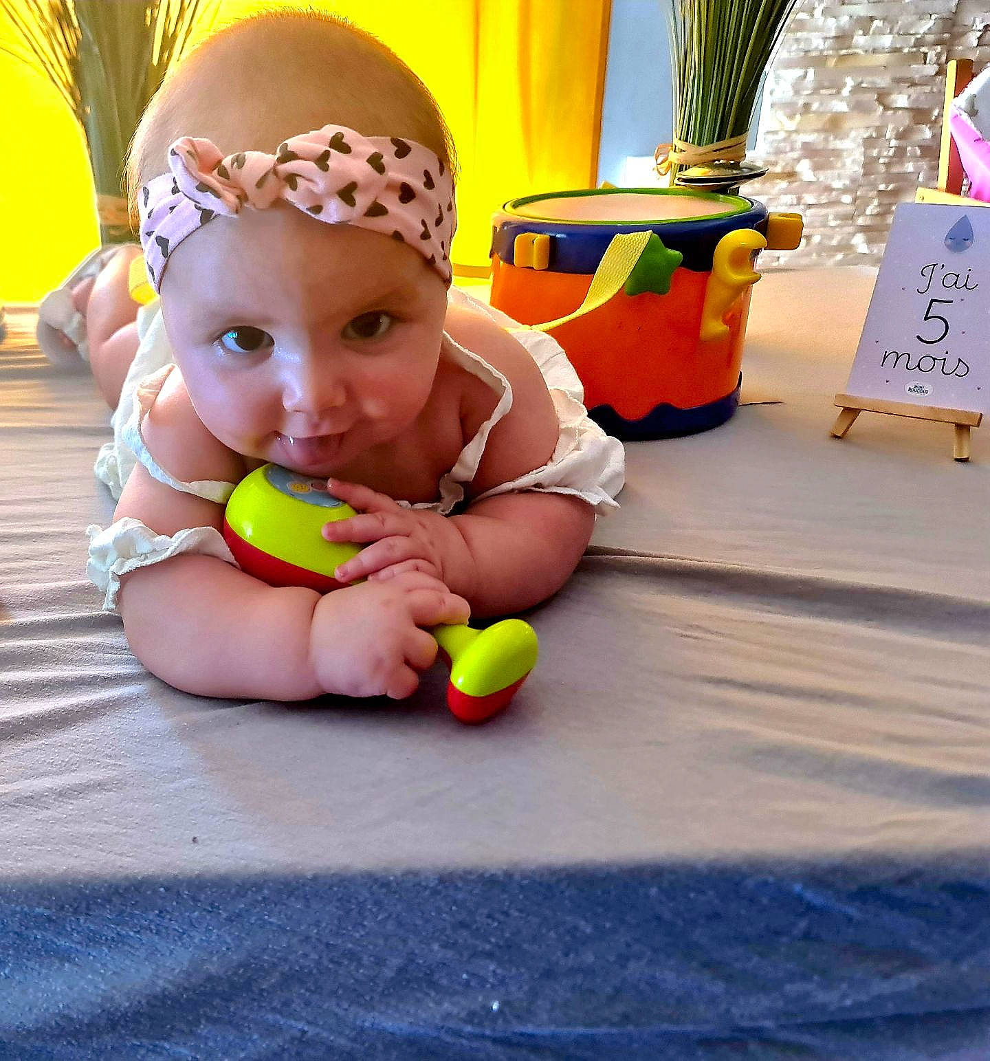 Alyannah participe au concours pour gagner de l'argent avec cette photo : baby, baby_playing_with_toys, baby_products, baby_toddler_clothing, child, event, flooring, flowerpot, fun, happy, headwear, houseplant, leisure, person, plant, play, recreation, room, sitting, toddler