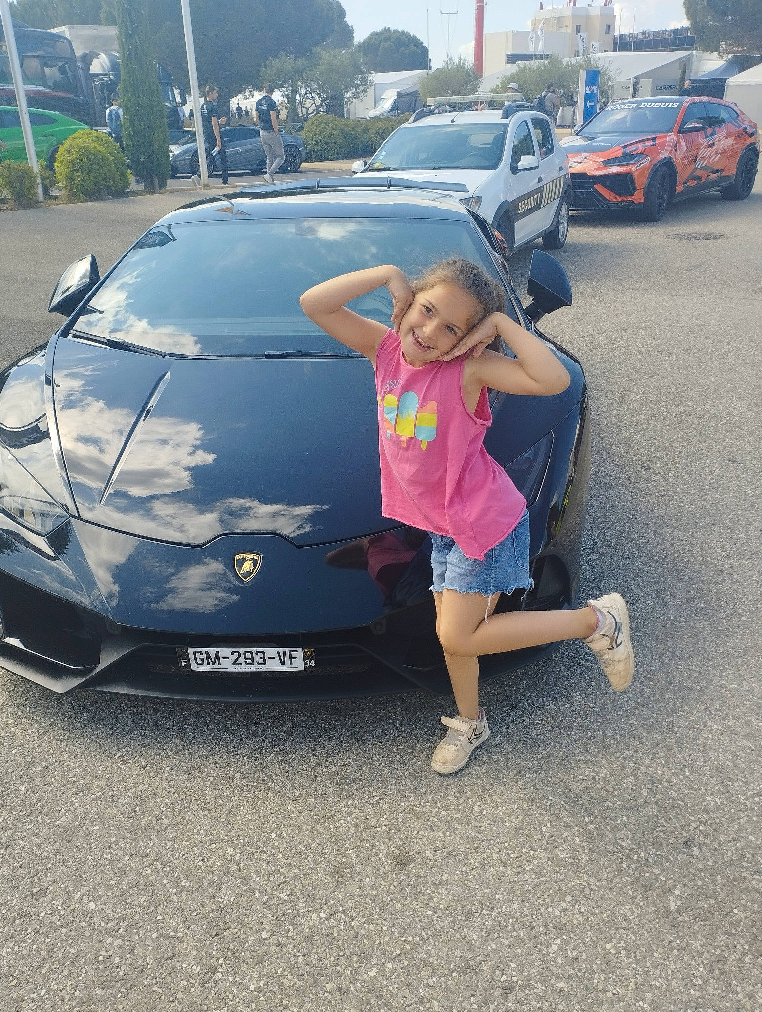 Lea participe au concours pour gagner de l'argent avec cette photo : asphalt, automotive_design, automotive_exterior, automotive_lighting, automotive_tire, automotive_wheel_system, bumper, car, hood, joy, land_vehicle, motor_vehicle, parking, person, personal_luxury_car, rim, shorts, tire, trunk, vehicle