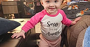 Rylee joined the competition — help win amazing prizes! baby, child, toddler, smiling, standing, walking, indoor, living_room, couch, furniture, blanket, lamp, clock, tablet, siblings, portrait, pink_clothing, long_sleeves, home, family