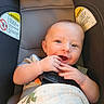 baby, car_seat, smiling, infant, hands, blanket, warning_label, child, seatbelt, cute, happy, face, indoor, person, safety, young_child, clothing, head, seat, skin