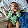 Major joined the competition — help win amazing prizes! baby, infant, child, green_clothing, onesie, bed, pillow, blue_blanket, hand_in_mouth, cute, smiling, skin, legs, face, sitting, indoors, comfort, sleeping_area, blanket, portrait