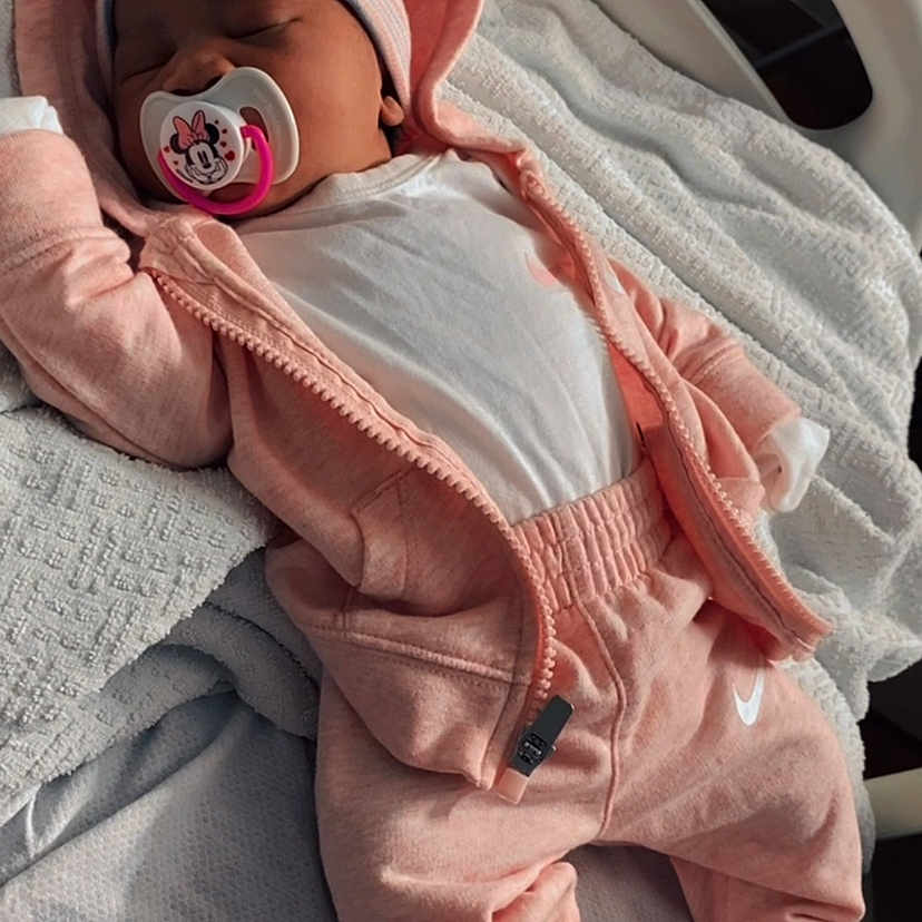 Naiari is registered to the contest to win money with this photo: baby, blanket, child, cozy, cute, hat, hoodie, hospital_bed, indoors, infant, newborn, pacifier, pajamas, pink_clothing, relaxing, sleep, sleeping, soft_light, striped_socks, white_clothing