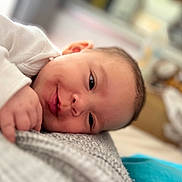 Ellana participe au concours pour gagner de l'argent avec cette photo : baby, infant, lying_down, blanket, closeup, face, skin, sleepy, hand, soft_texture, indoors, warm_lighting, peaceful, portrait, newborn, cute, cozy, resting, head, expression