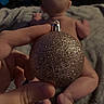 Miles is registered to the contest to win money with this photo: baby, bare_skin, hand, ornament, christmas_decoration, glitter, blanket, bed, fingers, naked, infant, back, toes, indoors, person, holiday, celebration, candid, closeup, skin