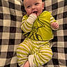 baby, blanket, checkered, child, cozy, cute, face, foot, green, hand, happy, indoors, infant, lying_down, pajamas, playful, portrait, smiling, striped_clothing, white