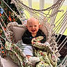 baby, blanket, child, cozy, cushion, cute, fabric, face, greenery, hammock, happy, home, indoor, pillow, portrait, quilt, seated, smiling, sock, window