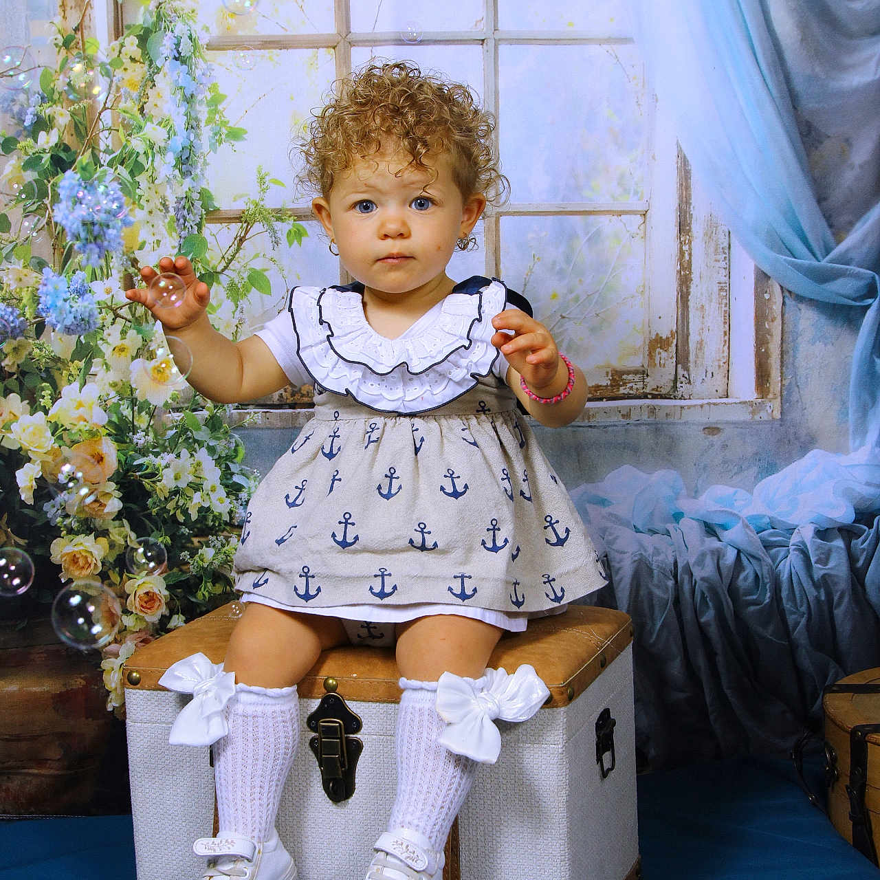 ève Horn participe au concours pour gagner de l'argent avec cette photo : anchors, blue, blue_eyes, bows, bubbles, child, curly_hair, curtains, cute, dress, flowers, indoor, playful, portrait, shoes, sitting, socks, toddler, trunk, window