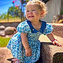 ève Horn participe au concours pour gagner de l'argent avec cette photo : toddler, child, smiling, blue_dress, floral_pattern, hair_accessory, outdoor, sunlight, stone_step, sandals, curly_hair, happy, cute, garden, greenery, daylight, portrait, person, baby, playful