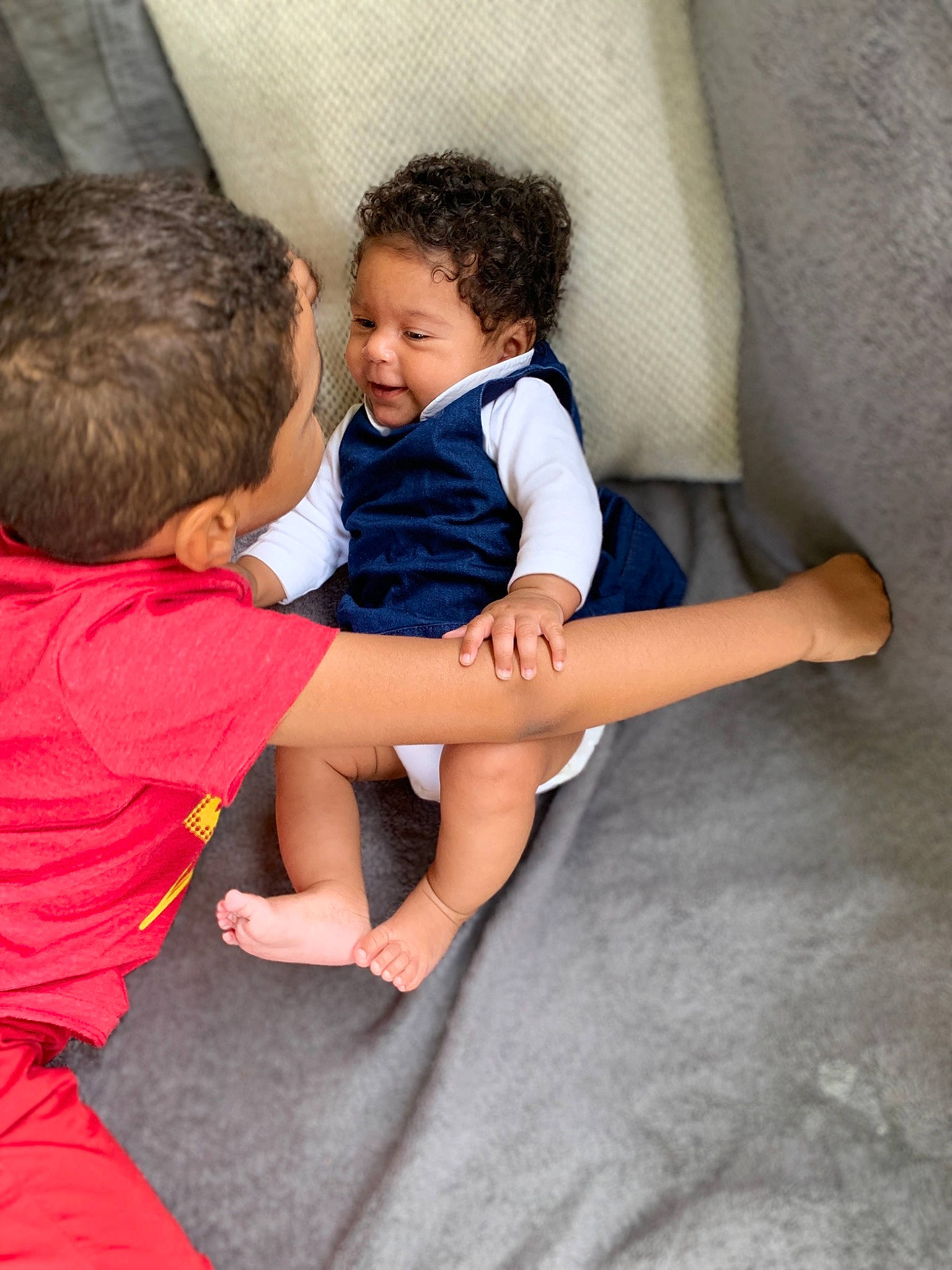 Charlize participe au concours pour gagner de l'argent avec cette photo : arm, barefoot, child, finger, fun, gesture, hand, interaction, joint, leg, leisure, person, play, sibling, sitting, toddler, vacation