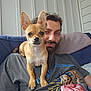 Ollie joined the competition — help win amazing prizes! dog, man, couch, indoor, pet, small_dog, beard, tshirt, graphic_tshirt, ears, face, relaxed, closeup, companion, curious, portrait, casual, cushion, smirk, home