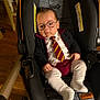 baby, child, car_seat, glasses, tie, clothing, indoor, person, infant, cute, serious, fashion, seat, footwear, socks, portrait, young, adorable, small, seated
