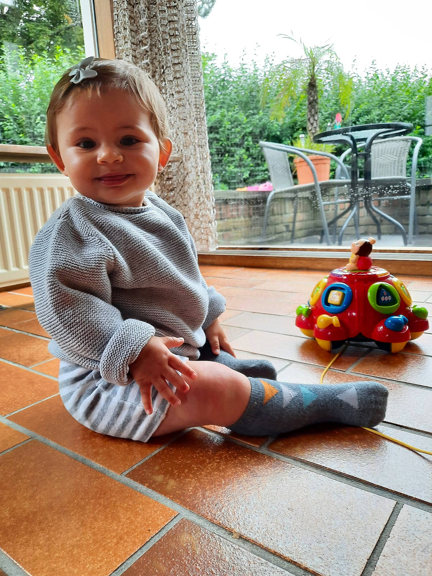 Maylis a rejoint le concours — aidez-le/la à gagner de superbes lots ! baby, baby_toddler_clothing, chair, child, floor, flooring, fun, grass, happy, hardwood, joy, leg, leisure, people, person, plant, recreation, sitting, smile, toddler
