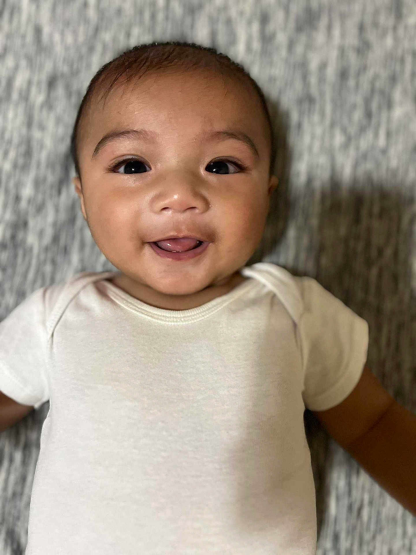 Nayahn joined the competition — help win amazing prizes! baby, infant, smile, face, eyes, tongue, white_onesie, lying_down, happy, closeup, skin, head, child, cute, portrait, cheeks, expression, soft_texture, indoor, person