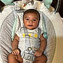 Nayahn is registered to the contest to win money with this photo: baby, infant, baby_seat, straps, clothing, toy, hanging_toys, smiling, face, person, indoor, cute, child, seat, comfort, playful, blue, gray, white, closeup