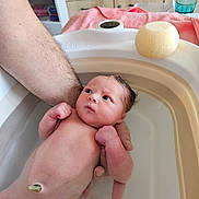 éloane participe au concours pour gagner de l'argent avec cette photo : newborn, baby, infant, bath, water, arm, skin, sponge, towel, hand, indoors, wooden_cabinet, sink, curious, wet_hair, person, bathroom, clean, young_child, caretaking