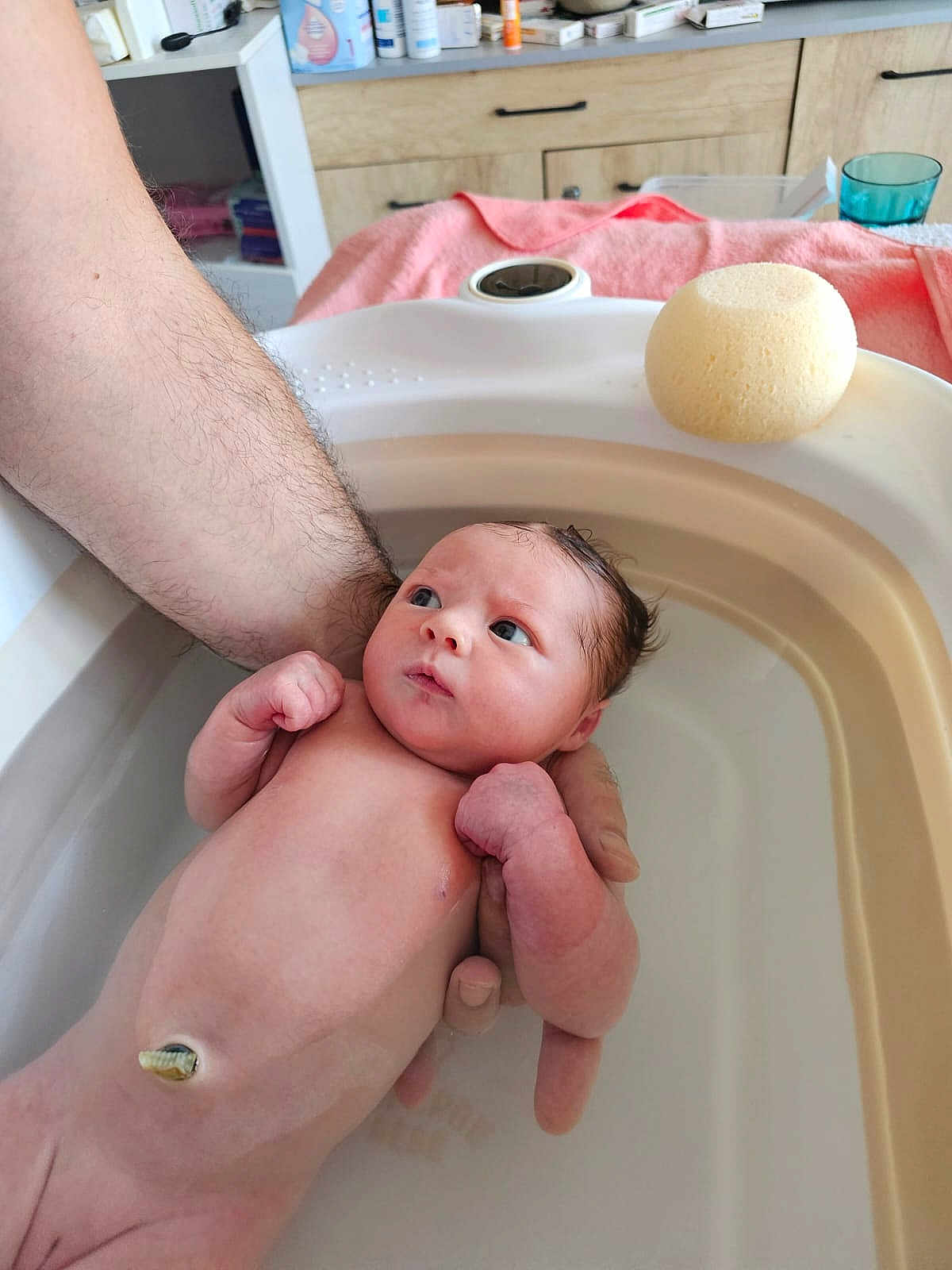 éloane participe au concours pour gagner de l'argent avec cette photo : newborn, baby, infant, bath, water, arm, skin, sponge, towel, hand, indoors, wooden_cabinet, sink, curious, wet_hair, person, bathroom, clean, young_child, caretaking