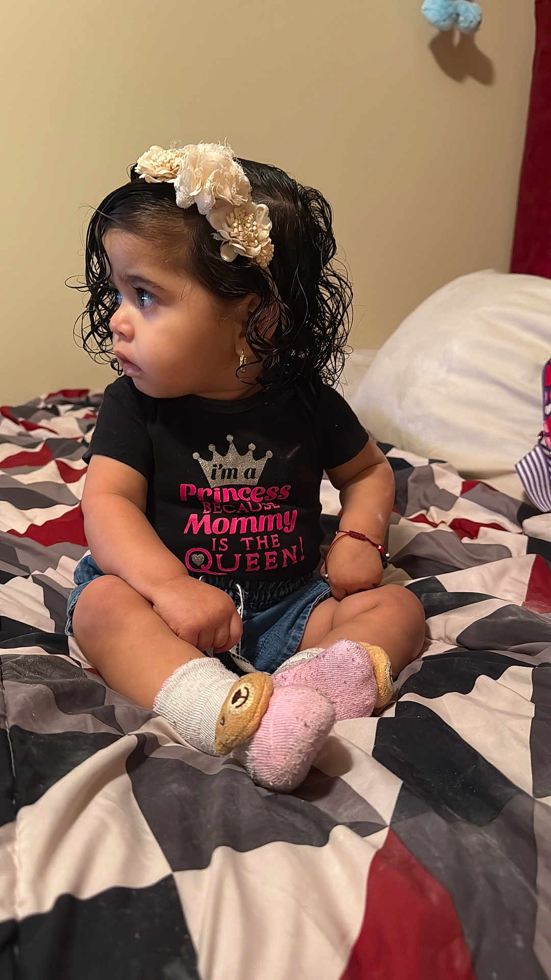 Estefani joined the competition — help win amazing prizes! bedroom, bedspread, black_shirt, bracelet, child, cross_legged, curly_hair, cute, earrings, expression, girl, headband, indoor, pink, portrait, shirt, sitting, socks, text_on_clothing, toddler