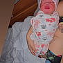 Alayah is registered to the contest to win money with this photo: newborn, baby, swaddle, sleeping, infant, bed, blanket, tattoo, person, hand, wood, pattern, animal_print, sleep, rest, indoor, soft_light, closeup, comfort, care