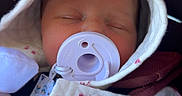 Jessie joined the competition — help win amazing prizes! newborn, baby, sleeping, pacifier, hood, blanket, floral_pattern, car_seat, infant, portrait, close_up, face, eyes_closed, bundled, pink, white, cozy, travel, child, peaceful
