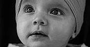 Louise participe au concours pour gagner de l'argent avec cette photo : baby, child, black_and_white, portrait, head_wrap, bow, knitwear, soft_texture, close_up, curious_look, infant, face, eyes, expression, studio_lighting, cozy, cute, young_child, monochrome, innocence