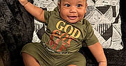 Kazi joined the competition — help win amazing prizes! baby, child, clothing, couch, cute, fabric, face, footwear, green, happy, indoors, pattern, person, pillow, relaxed, sandals, sitting, skin, smiling, text