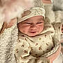 Janna participe au concours pour gagner de l'argent avec cette photo : baby, infant, smile, face, blanket, hat, clothing, floral_pattern, cozy, cute, newborn, soft_texture, warm, indoors, person, portrait, child, sleepwear, resting, happy