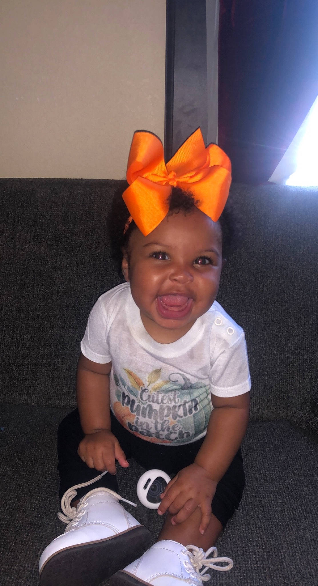Kaylani is registered to the contest to win money with this photo: baby, baby_toddler_clothing, cap, child, costume_accessory, costume_hat, fashion_accessory, flooring, fun, happy, hat, party_supply, person, personal_protective_equipment, room, sitting, sleeve, smile, t_shirt, toddler